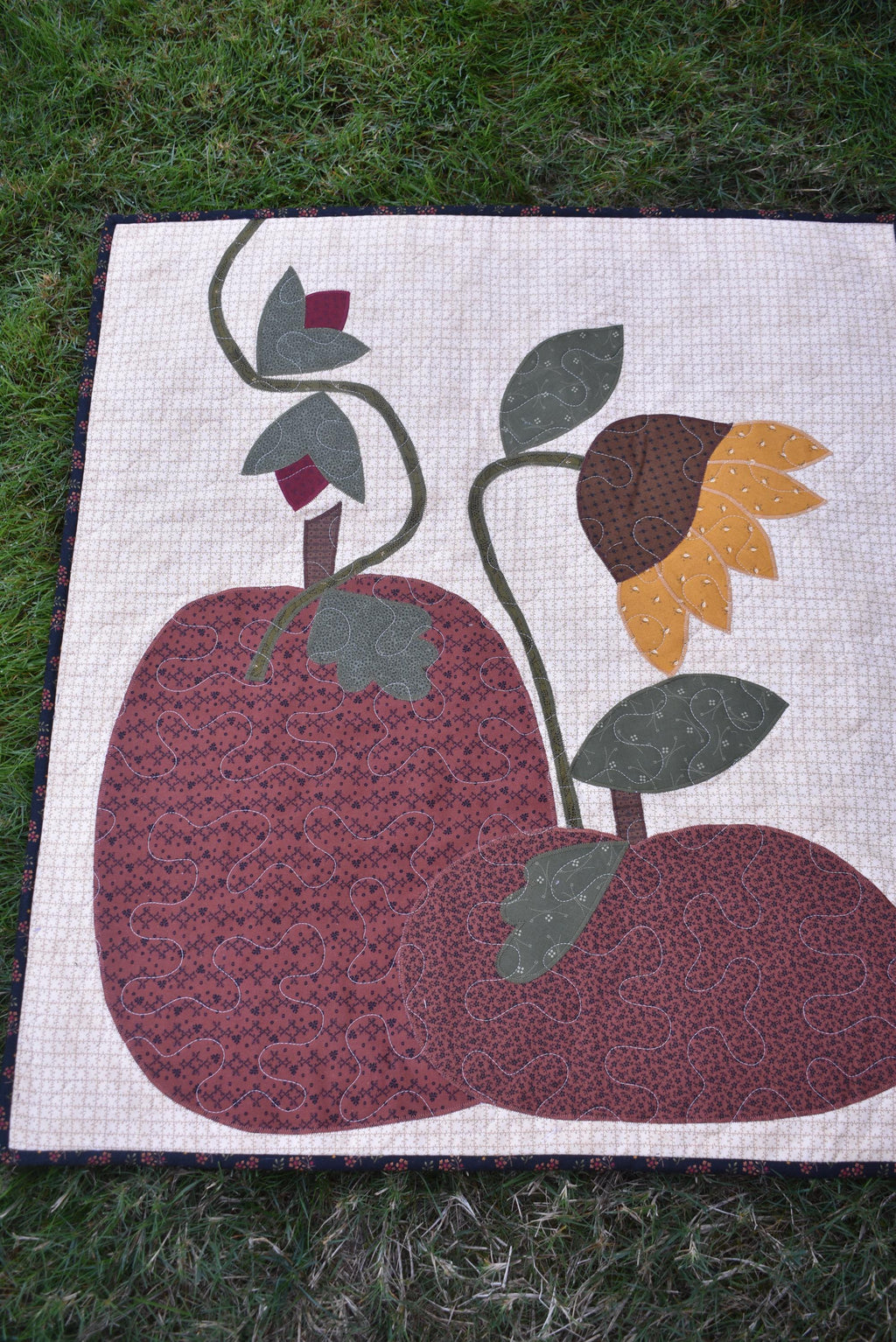 Quilt:  A Quilt measuring 30" high by 26.5" wide    Featuring Two Pumpkins, a Sunflower and other Flowers