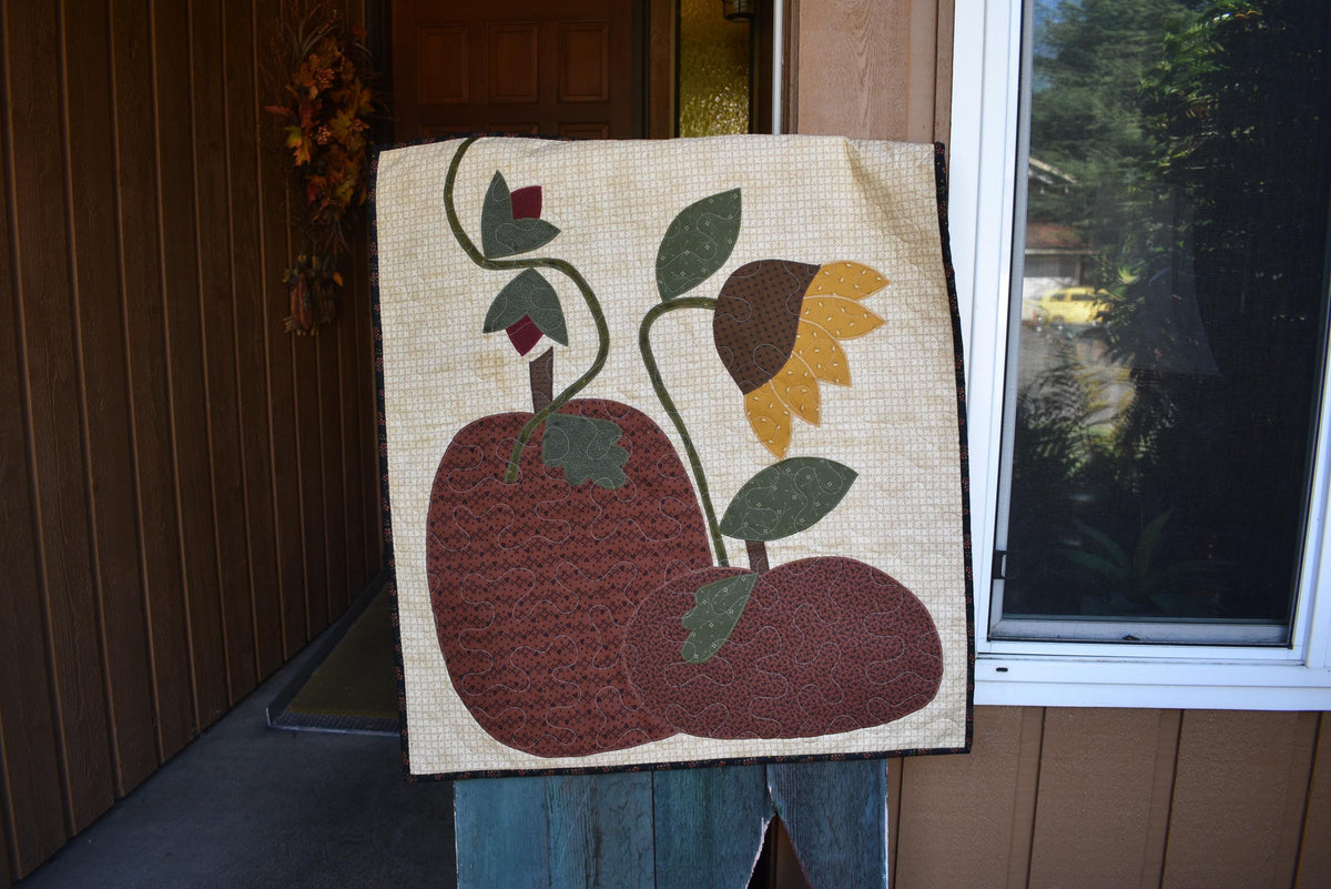 Quilt:  A Quilt measuring 30" high by 26.5" wide    Featuring Two Pumpkins, a Sunflower and other Flowers